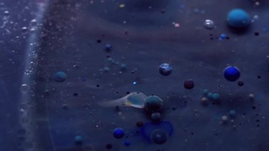 Emülsiyonu bırak. Yağ sıvısı. Renk pigmenti topları ile koyu, gizemli mavi yüzey kozmik akışı sağlar. Bulanık boya soyut su arkaplanı.