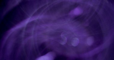 Bulanık renk parıltısı. Odaklanamayan ışık patlaması. Mor neon rengi parlak yanıp sönen bokeh daireler koyu soyut arkaplanda parıldıyor.