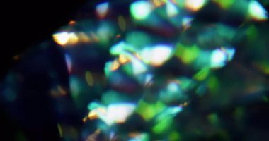 Çoklu renk titreşimi. Bulanık mercek gökkuşağı. Odaklanmamış yeşil mavi ışık parıltısı soyut sanat koyu siyah arkaplan üzerinde parıldıyor.