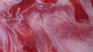 Leke sızıntısı. Parlak mürekkep. Odaklanmamış renkli parlak toz cilası parçacıkları soyut arkaplanı harmanlıyor. Turuncu kırmızı beyaz sıvı pigment dökülüyor.