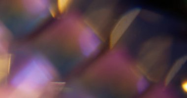 Işın aydınlatıldı. Bulanık yanardöner sızıntı. Odaklanamayan altın rengi mor çok renkli mercek soyut sanatın koyu siyah arka planında yüzüyor..