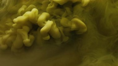 Boya damlası suyu. Duman bulutu. Odaklanmamış sarı renk buhar dokusu mürekkep sıvısı damlası soyut sanat arka planına yayılıyor..