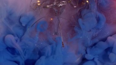 Duman patladı. Boya çözülüyor. Soyut arkaplan ampulü üzerinde parlak renk akışları çakışır. Süt gibi köpüklü suda canlı mavi bulut.