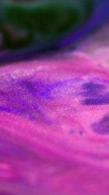 Dikey video. Parlak mürekkep akışı. Boya karışımı. Bulanık, mavi, parlak, siyah parçacıklar. Doku cilası, dalga, cazibe, soyut sanat arkaplanı..