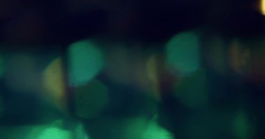 Bokeh enerjisi. Bulanık ışın soyut. Odaklanmamış yeşil mavi, çok renkli, yanıp sönen ışık, sihirli mercek dokusu koyu siyah arkaplanda..
