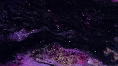 Parıltı karışımı. Mermer dokusu. Odaklanamayan mor renkte parıldayan sıvı boya, ışıldayan parlak parçacıklar, soyut sanat arka planında hareket ediyorlar..