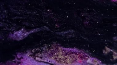 Parıltı karışımı. Mermer dokusu. Odaklanamayan mor renkte parıldayan sıvı boya, ışıldayan parlak parçacıklar, soyut sanat arka planında hareket ediyorlar..
