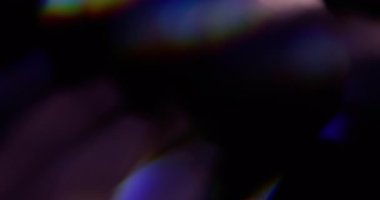 Gökkuşağı yansıması. Bulanık ışık. Odaklanmamış mavi, yeşil, parlak ışık spektrumu soyut koyu siyah arkaplanda titreşiyor..