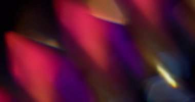 Lens ışığı. Bulanık yanardöner doku. Soyut koyu siyah arkaplanda sönük sarı mor renkli gökkuşağı tayfı parlaklığı.