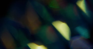 Işın sızıntısı. Bulanık yanardöner doku. Soyut koyu siyah arkaplanda sönük sarı renkli gökkuşağı spektrum ışık parlaması.