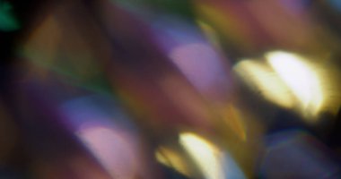 İşaret fişeği. Bulanık ışık merceği. Soyut koyu siyah arkaplanda çözünmüş mor yeşil çoklu renk spektrumu yanardöner dokusu.