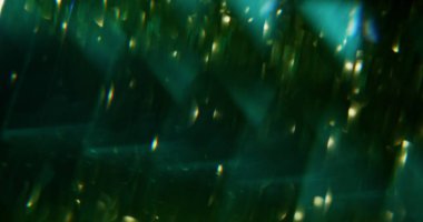 Parlak ışıklar. Odaklanamayan ışıldayan ışıltı. Bokeh efektli koyu siyah soyut arka planda parlak yeşil parlaklık.