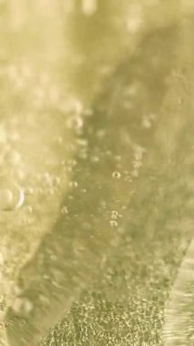 Dikey video. Yağ kabarcığı kıvrılıyor. Sıvı gaz dokusu. Odaklanamayan altın sarısı renk berrak su emülsiyonu spiral yakıt akışı parlak soyut sanat arka planı.