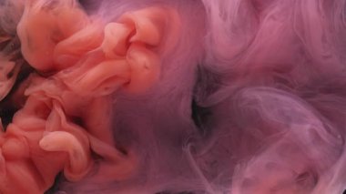 Renkli duman dokusu. Suyu boya. Odaklanmamış mor turuncu bulut sıçrama sıvısı soyut koyu siyah arkaplan üzerinde hareket ediyor.