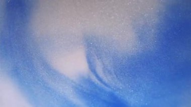 Mürekkep karışımı. Parıldayan sıvı dökülmüş. Soyut mermer arka planda yüzen parlak su dokusunda çözünmüş mavi beyaz renkli boya..