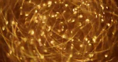 Hafif bir çelenk. Odaklanamayan altın parıltı. Işıl ışıl sarı, yanıp sönen daireler soyut Bokeh üzerinde hareket ederken modern arka plan bulanıklaştı..