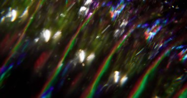 Göz kamaştırıcı akış. Odaklanamayan parlak çizgiler. Mavi kırmızı yeşil yanıp sönen mercek soyut bokeh açık koyu siyah arkaplanda bulanık ışık hareketi.