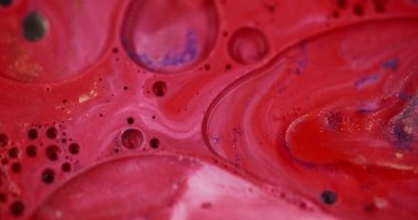 Şeffaf kabarcıklar. Odaklanamayan renk sıvısı. Işıldayan parlak akışkan boya hareketi soyut kırmızı bulanık bokeh ışığı modern arka plan.