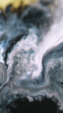 Dikey video. Acryl dalga damlası. Sıvı sanat. Parlak folyo rengi soyut arkaplan üzerine odaklanmış siyah sıvı mürekkep karışımı parçacık dokusu.