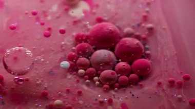 Akrilik kütle. Yağ kabarcıkları. Pembe pigment topları saydam bulanık sanat sıvısı mermer içinde yüzüyor. Titreyen su, soyut arka plan yüzeyi..