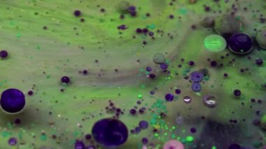 Mürekkep akışı. Köpük boyası. Yüzen çok renkli sanat sıvısı su dokusunu düşürür. Fantezi yeşil menekşe parçacıkları soyut arka plan sıvısı katmanlı.