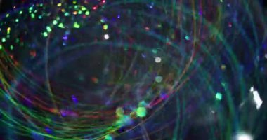 Kaleydoskop yansıması. Odaklanamayan şenlik titreşimleri. Bulanık bokeh ışık arka planında hareket eden çok renkli parçacıkların parlamaları.