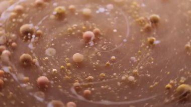 Döndürme sıvısı. Yağ damlası akışı. Katmanlı mermer dairesel spin karışımı su soyut çözülmüş arka planda kahverengi bej mürekkep topları etrafında.