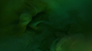Mistik duman. Boya akışı. Sanat suyunda yeşil mürekkep tozu bulutu patlaması. Atmosferik soyut koyu parlak renk çözünmüş doku.