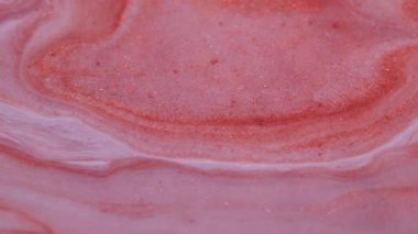 Boya akışı. Kimyasal parıltı. Turuncu bakır beyaz boya parıldayan sıvı dokuya yayılmış. Pürüzsüz karışık parçacıklar soyut arkaplanı bulanıklaştırır.