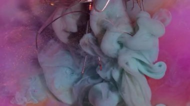 Mürekkep lekesi. Çok renkli duman. Kırık cam parçalarını yıkayan dalgalı sıvı sis. Işıldayan pembe gri mavi soyut arkaplan sanat suyu.