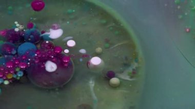 Akrilik kütle. Mürekkep patladı. Parıldayan sızıntı, şeffaf dairesel pigment renk baloncukları. Yeşil mor sanat soyut arkaplan.