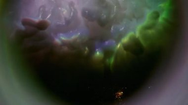 Parıltı akışı. Gökkuşağı dumanı. Parlak patlama mürekkebi soyut arka planda parıldıyor. Mor mor gümüş yuvarlak bulanık lens.