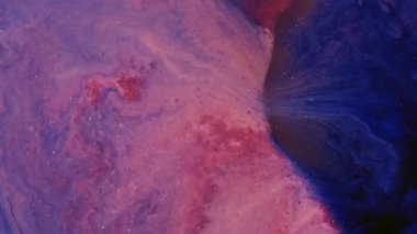 Boya dökülmüş. Sanat sıvısı. Pembe mor sıvı karışım boya renk parçacıkları soyut bulanık arkaplan. Pigment damlası akışı mermer parıldayan doku.
