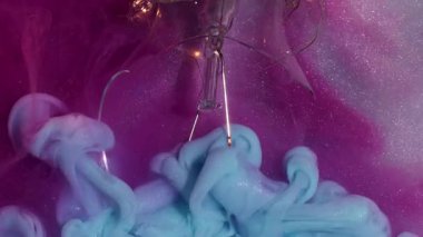 Mistik mürekkep. Işıl ışıl. Pembe gümüş metalin arka planında patlayan mavi sisli duman. Soyut parlayan ampul yüzeyi.