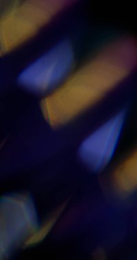 Şafak. Bulanık lazer. Soyut sanatın koyu siyah zeminine odaklanmış mavi sarı, çok renkli gökkuşağı spektrum ışığı.