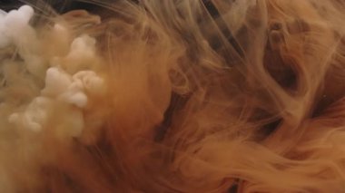 Renkli duman dokusu. Suyu boya. Soyut koyu siyah sanat arka planında hareket eden beyaz, sarı, ruhani bulutsal damla sıvısı..