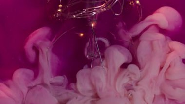 Sıvı patlaması. Boya dumanı. Pembe köpüklü suda peçe mürekkebi dalgalanması. Kırık parlayan ampul dekoratif sanat soyut arka planı.