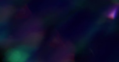 Aydınlatılmış sızıntı. Bulanık alev dokusu. Odaklanmamış yeşil mavi çoklu renkli gökkuşağı ışığı soyut sanat koyu siyah zemin üzerinde yanıp sönüyor.