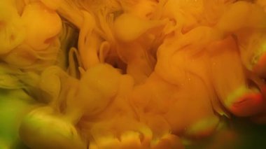 Boya buharı. Hipnoz sıvısı. Yeşil ışıldayan soyut arkaplana turuncu resim karışımı mürekkep dökülmüş. Gökkuşağı renk bulanık ışın su lensi.