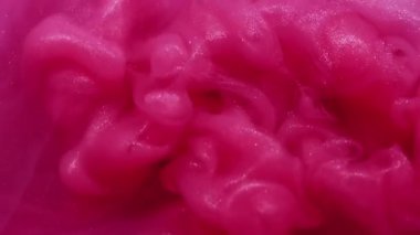 Parıldayan sıvı. Pigment akışı. Islak, soyut, bulanık arkaplanda pembe, parlak boya şişirme dalgası dökülmüş. Yumuşak sis rengi kıvrımlı su dumanı.