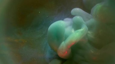 Hipnoz sıvısı. Parıltı akışı. Işıldayan renkli mürekkep spreyi dumanı çözünmüş sisli su arka planı. Soyut fantezi sıçrama dokusu.