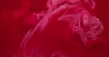 Mürekkep suyu. Sis dalgası. Odaklanmamış kırmızı renk sıvı partiküller kimyasal duman akrilik madde soyut arka planda dönüyor.