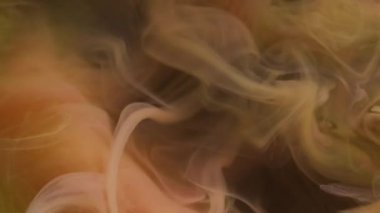 Buhar dokusu. Sis boyası. Siyah arka planda süzülen sarı turuncu sis örtüsü. Renk bulutu su soyut büyülü sanat dumanı bulanıklığı.