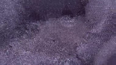 Boya akışı. Mürekkep arkaplanı. Odaklanmamış mor renk kimyasal sıvı karışım su dokusu sıçrama damlası soyut siyah sanata dökülüyor.
