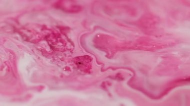 Bokeh pigment akışı. Parlak bir geçmişi var. Odaklanmamış pembe beyaz renkli boyalı su desenli mermer diş minesi sıvısı soyut sanatta ilerliyor.