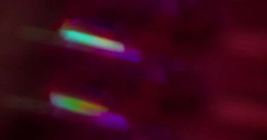 Bulanık holografik gökkuşağı. Kaleydoskop titreşimli ışınlar. Garland neon yeşili, bokeh ışık arka planında çok renkli pırıltı hareketini parlatır.