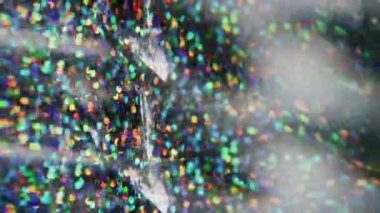 Konfeti örtüsü. Bulanık fantezi titreşimi. Renkli kırmızı, sarı, ışıl ışıl parçacıklar, arkaplanda Bokeh efektiyle parlayan mercek..