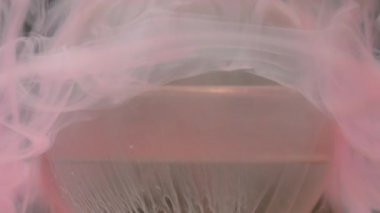 Sis bulutu. Boya balonu. Su geometrik yuvarlak şekilli pembe mürekkep. Soyut koyu siyah arkaplan üzerine damlayan kimyasal sıçrama sıvısı..