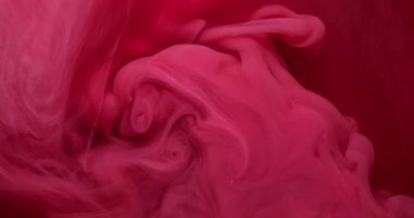 Mürekkep suyu. Boya karışımı. Odaklanmamış kırmızı, pembe, dumanlı, simli, sisli kimyasal sıvı soyut sanat arka planında yükseliyor..