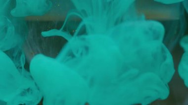 Sis mürekkebi. Su bulutu küresi. Yoğunlaşmamış mavi altın rengi sıvı toz boyası soyut sanatının koyu siyah arka planında şeffaf baloncuğun üzerine yayılıyor..